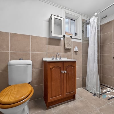 Modern bathroom featuring a sleek shower and functional design with ample storage options.