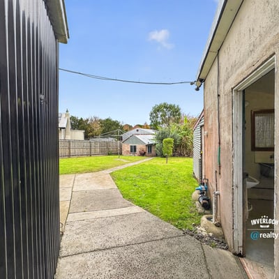Spacious backyard with landscape potential, featuring accessible pathways and neighboring properties for a vibrant community feel.