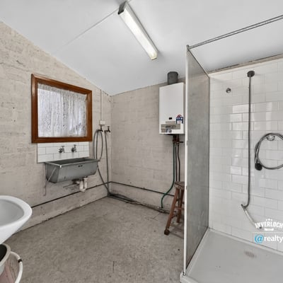 Spacious bathroom featuring a modern shower, practical sink area, and ample natural light.