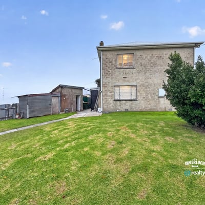Spacious two-story home on a generous lot, featuring ample outdoor space and a detached shed.