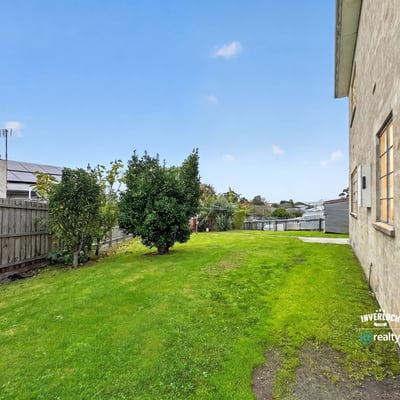 Spacious, grassy side yard offers potential for landscaping or outdoor activities, enhancing the property's appeal.