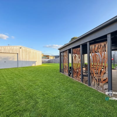 Spacious backyard featuring distinctive decor and a large garage, perfect for outdoor gatherings and hobbies.