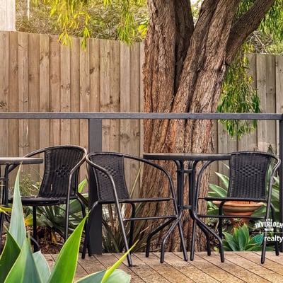 This inviting outdoor space features comfortable seating surrounded by lush greenery, perfect for relaxation or gatherings.