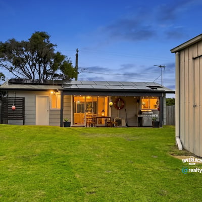 This inviting home features spacious green yard, modern amenities, and a cozy outdoor living area.