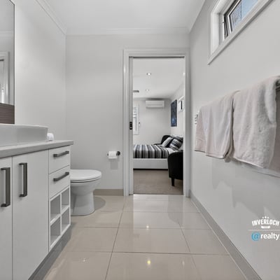 Modern bathroom featuring sleek cabinetry and contemporary finishes, seamlessly connecting to a cozy living area.