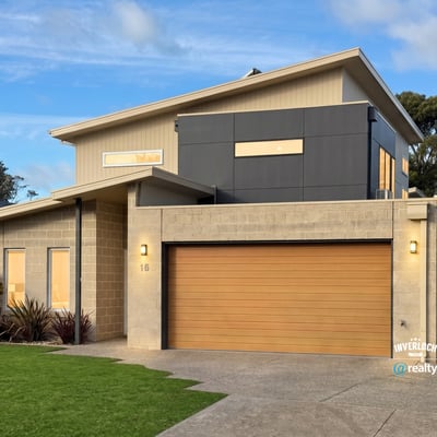 Contemporary home featuring unique architectural design, spacious garage, and vibrant landscaping in a desirable neighborhood.