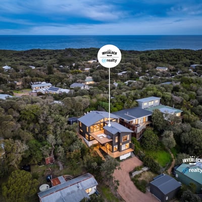 This coastal home offers breathtaking ocean views and modern architecture, nestled among lush greenery.