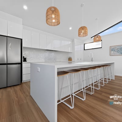 Modern kitchen featuring sleek cabinetry, a spacious island, natural light, and contemporary pendant lighting.