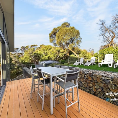 Modern outdoor patio seamlessly blends with nature, featuring ample seating and vibrant landscaping. Perfect for gatherings!