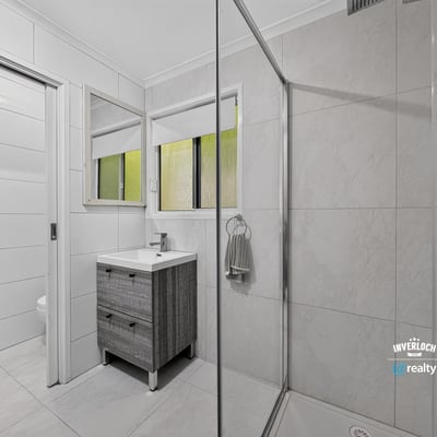 Modern bathroom featuring dual mirrors, a spacious shower, and sleek cabinetry for efficient storage.