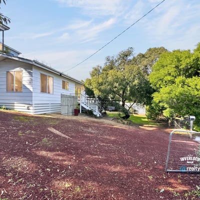 Bright, inviting home on a hillside lot, featuring expansive outdoor space and potential for personalization.