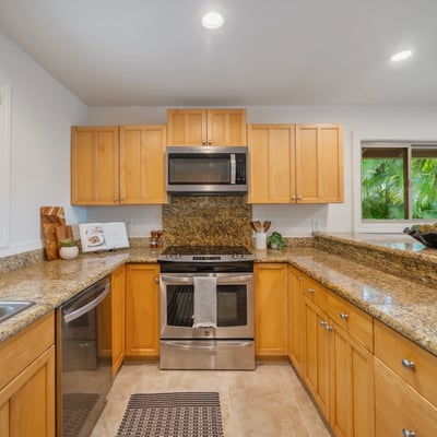 This inviting kitchen features modern appliances, ample counter space, and views of lush greenery.