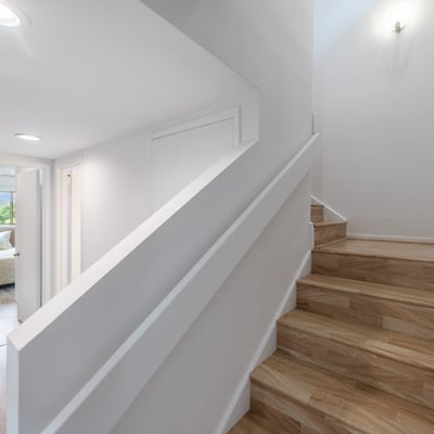Bright, modern stairway leading to a spacious living area, showcasing open design and natural light.