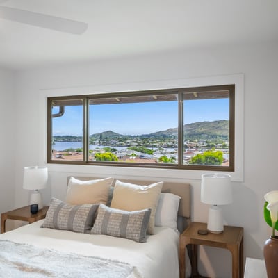 Bright bedroom featuring panoramic views of the waterfront and nearby hills, perfect for tranquil mornings.