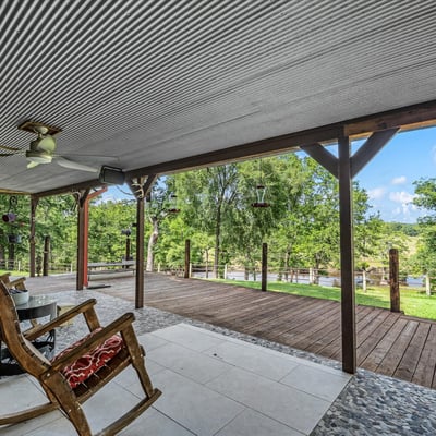 Spacious covered porch overlooking lush greenery, perfect for relaxation and outdoor gathering opportunities.