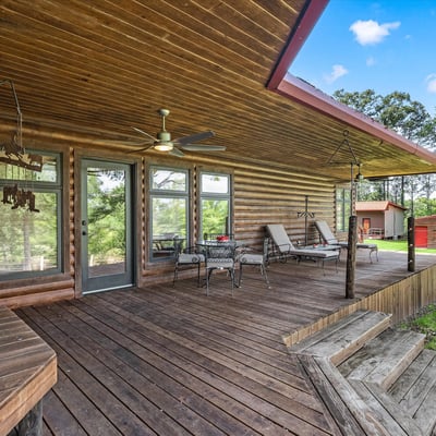 Spacious log home featuring a generous porch, ideal for outdoor living and relaxation surrounded by nature.