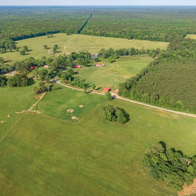 Expansive rural landscape featuring open fields, mixed woodlands, and potential for agricultural or recreational use.