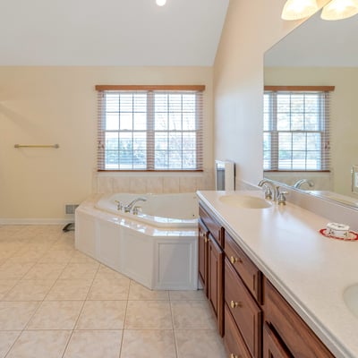 Primary Bathroom has a beautifully tiled shower, high ceiling with recessed lighting, and natural light.