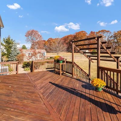 A paver walkway off the deck leads to the spacious fenced-in yard, paver patio, garden shed, and gate to the driveway.