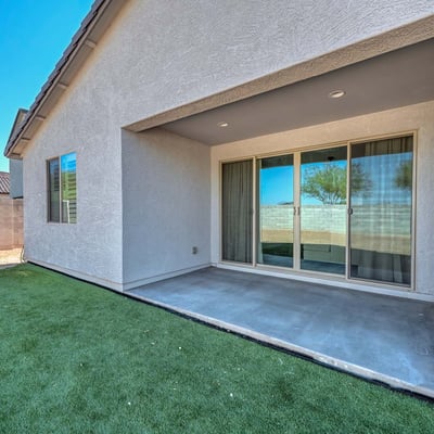This covered patio is the perfect extension of indoor living ideal for shaded relaxation or hosting guests year-round. The smooth concrete flooring and direct access through sliding doors add comfort and convenience to this Peoria backyard retreat.