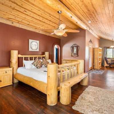 Open-concept owner s suite with loft-style design, hardwood floors, and handcrafted log details that create a serene private retreat.
