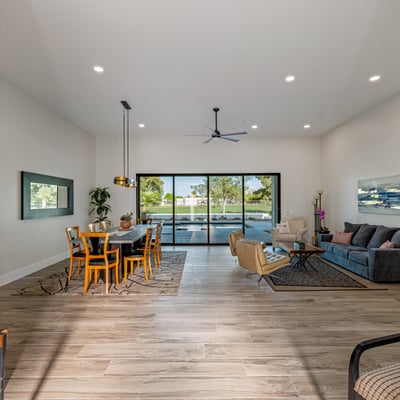 The great room blends dining and living areas with high ceilings, wood-look flooring, and seamless backyard access.