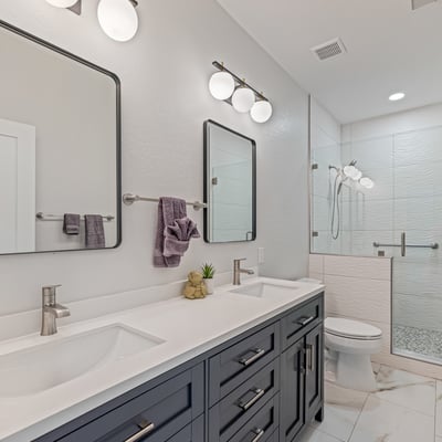 Updated hall bathroom with dual vanities, stylish lighting, and a bright, fresh design adds convenience and elegance.