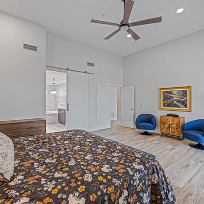 The spacious owner s suite includes tall ceilings, ample room for seating, and access to outdoor living areas.