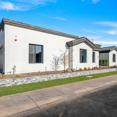 Modern desert-friendly landscaping with stone planters and fresh plantings frames the Scottsdale home. Perfect for low-water use and easy maintenance.