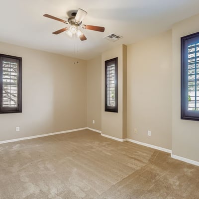 Fourth bedroom at the front of the home features plantation shutters, ceiling fan, and flexible design potential.