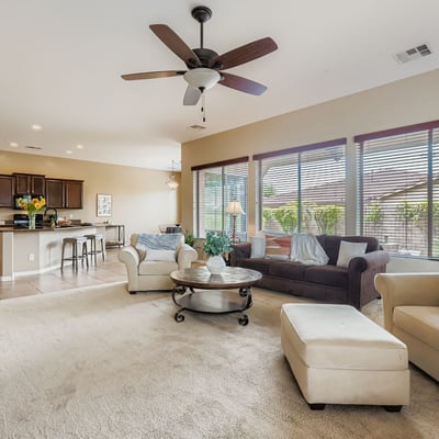 Large windows fill the living area with natural light while providing direct views to the backyard patio and landscaped outdoor space.