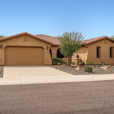 Native desert plants and low-maintenance landscaping highlight the front yard of this Peoria home, blending beauty with efficiency.