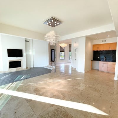 Open-plan living and dining area with glossy tile floors, recessed lighting, and a convenient wet bar for easy entertaining.