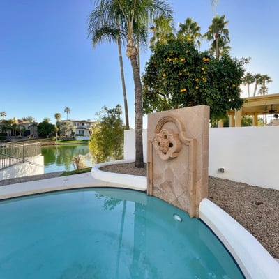 Enjoy resort-style living by the lake with a stone water feature and tranquil palm-framed surroundings that define Scottsdale luxury.