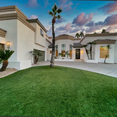 Twilight lighting enhances the warm tones of this modern Scottsdale home, highlighting palm silhouettes.