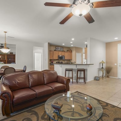 The open great room showcases tile flooring, neutral colors, and recessed lighting. Ideal for entertaining, it seamlessly connects to dining and kitchen spaces.