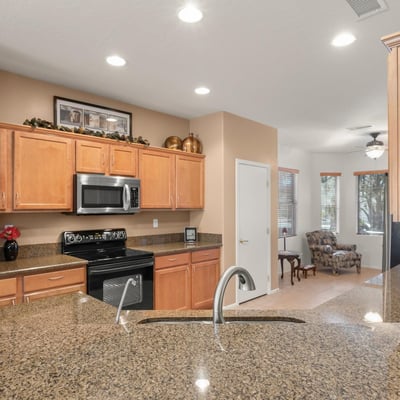 The kitchen shines with durable granite countertops, stainless fixtures, and warm tones offering both elegance and easy maintenance for Arizona living.