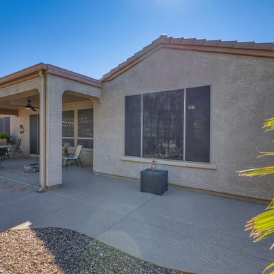 Enjoy the comfort of this covered patio space, complete with ceiling fan and desert views ideal for relaxation or casual gatherings.