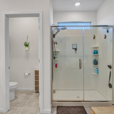 A clean and spacious bath with glass shower enclosure, private toilet area, and modern detailing enhancing daily comfort in this Litchfield Park home.
