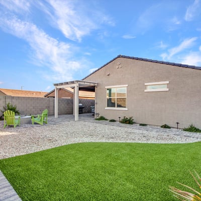 Featuring a blend of artificial turf and desert rock landscaping, this spacious backyard offers plenty of room for relaxation in Litchfield Park.