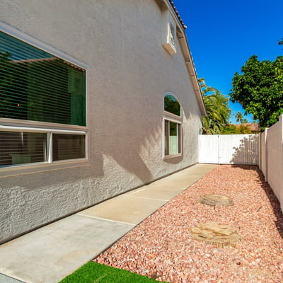 Side yard pathway with desert landscaping and gravel ground cover designed for easy upkeep. This Scottsdale outdoor area provides practical access around the home while maintaining a clean and organized appearance.