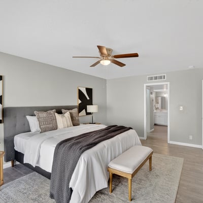 Calm and inviting primary suite with neutral tones, ceiling fan, and a spacious layout ideal for relaxation.
