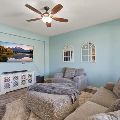 Front living room featuring soft natural light, updated flooring, and comfortable seating space perfect for relaxing or welcoming guests.