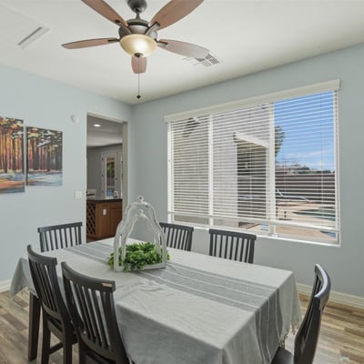 Dining space overlooking the backyard retreat with pool and spa, allowing natural light to fill the room and connecting indoor dining with outdoor living.