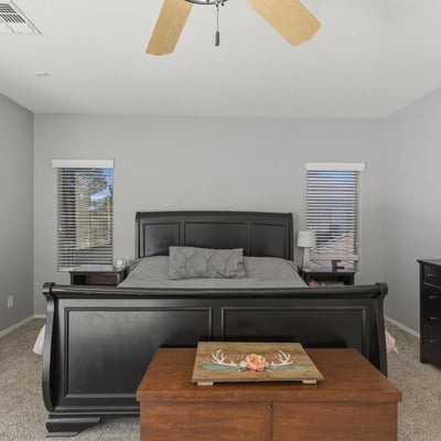 Bright primary bedroom with neutral finishes, ceiling fan, and expansive floor space offering comfort and versatility within the home s upper level.