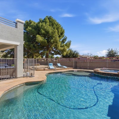 Sparkling backyard pool with spa, stone decking, and lounge space surrounded by mature trees for added privacy and shade.