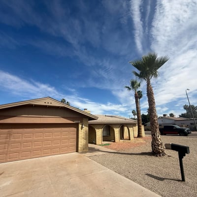 Front entry and garage view highlighting the arched porch architecture and spacious driveway. This Glendale property features a practical layout with attractive curb appeal.