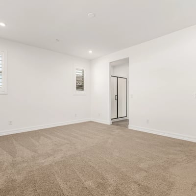 Generous primary suite with soft carpet, large windows, and peaceful ambiance. Designed for comfort and privacy.