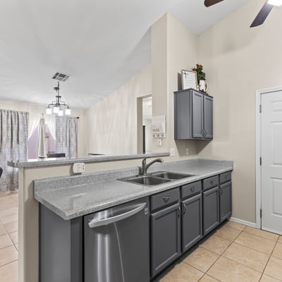 Functional kitchen featuring ample cabinetry, generous counter space, and included appliances, all open to the main living areas