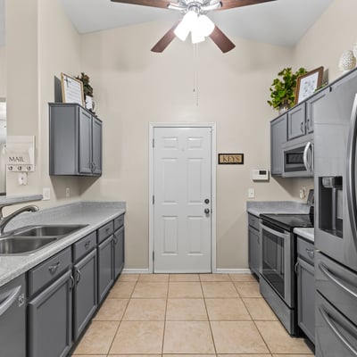 Stylish kitchen showcasing stainless steel appliances, generous cabinet storage, and functional layout open to main living areas.